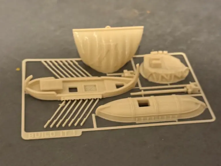 3D-gedruckte Bausatz-Karte mit den Einzelteilen eines Schiffsmodells im Rahmen