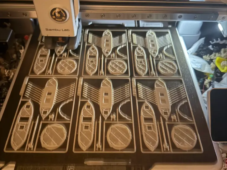 Druckplatte eines 3D-Druckers mit sechs Bausatz-Karten für Schiffsmodelle