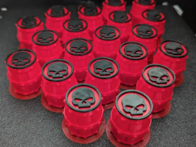 Rote 3D-gedruckte Spielsteine in Fassform mit schwarzem Emblem