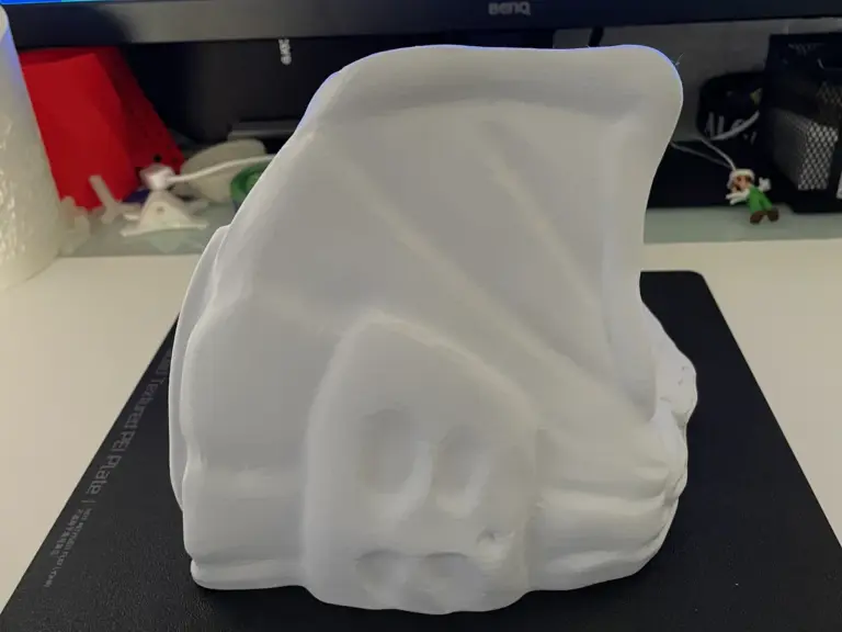 Weißes 3D-gedrucktes Haus, das sich zur Seite biegt, auf der Druckplatte
