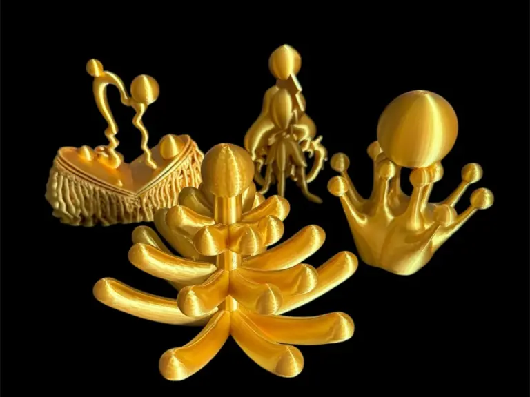 Vier goldfarbene 3D-gedruckte Skulpturen vor schwarzem Hintergrund