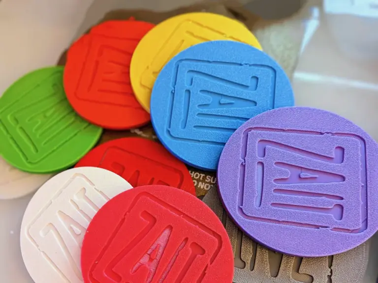 Runde 3D-gedruckte Untersetzer mit erhabenem Logo in Rot, Gelb, Blau, Lila, Grün und Weiß